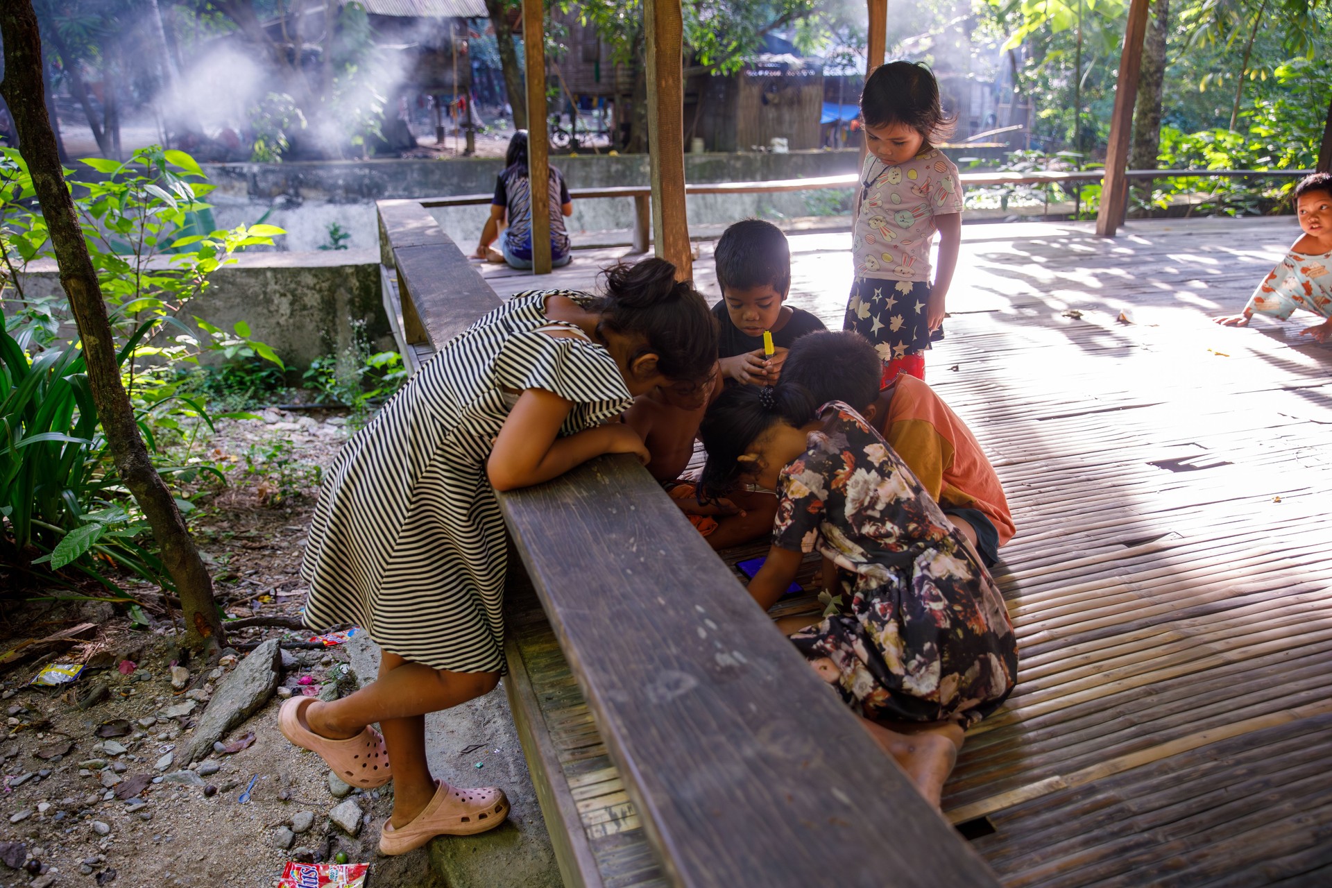 June 2 2025 Mangyan Village Talipanan Oriental Mindoro Philippines, Filipino children watching smartphone screen together outdoors