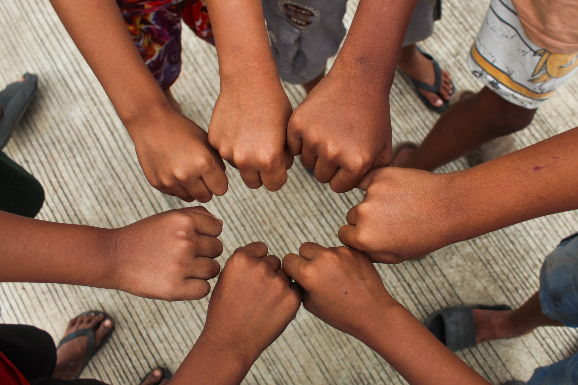 Boys, join hands and together for solidarity, support and achievement for growth in sports games. Children for teamwork, success and development with a shared commitment above.